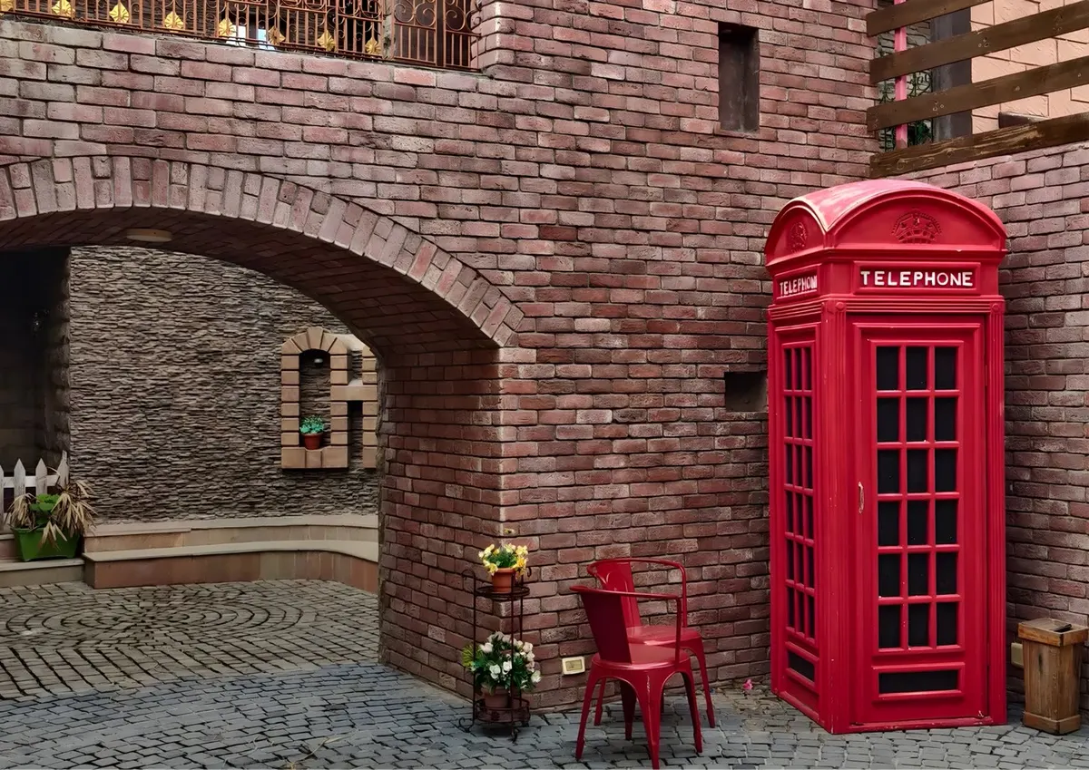 Patio con muro de ladrillo, arco y pavimento de adoquín